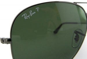 Gros plan sur le logo Ray-Ban inscrit en blanc sur le verre droit d'une paire authentique